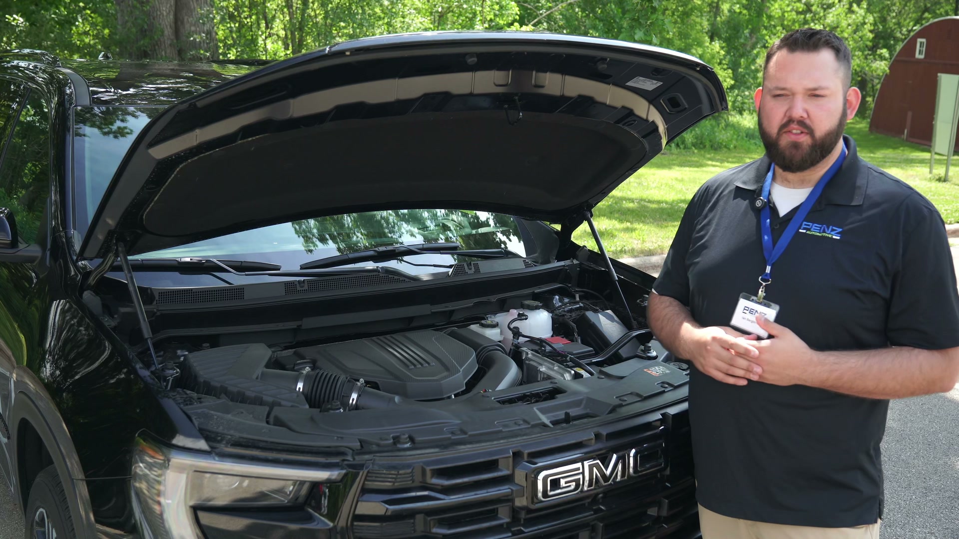 Ian from GMC of Rochester standing beside a 2026 GMC Acadia with the hood open